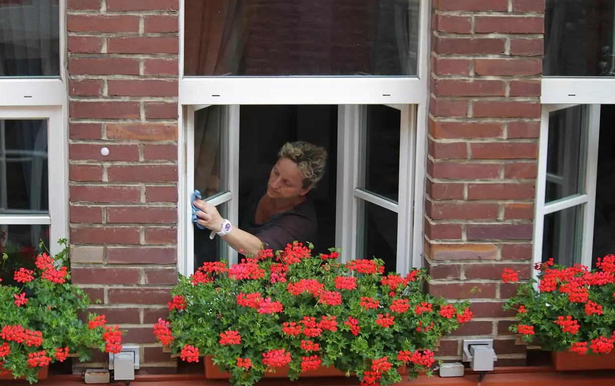 Putzfrau reinigt Fensterscheiben